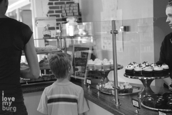 boy looking at cupcake counter