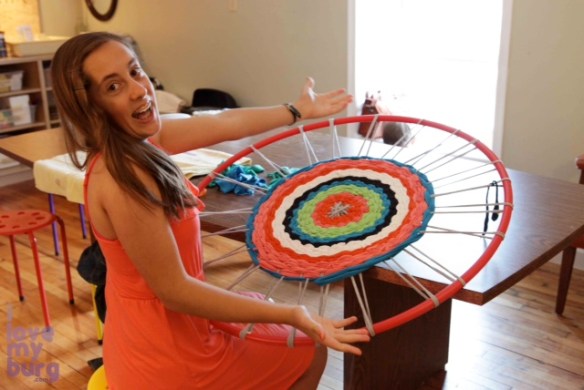 girl weaving hula hoop rug